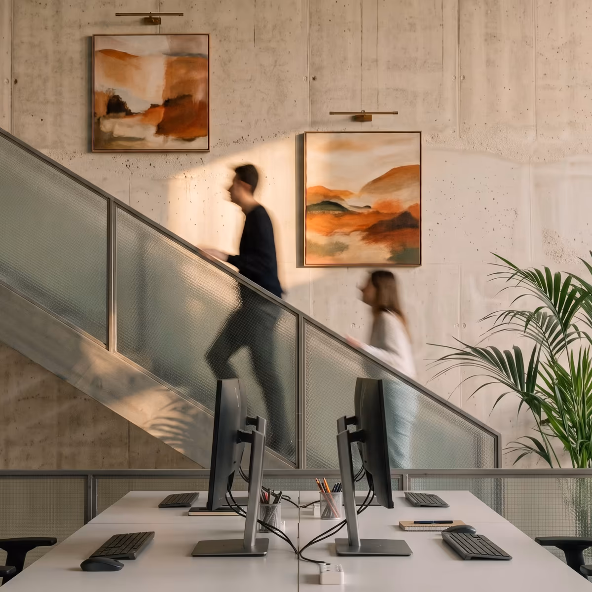 Colleagues on the stairs of a modern brokerage office above an open-plan workspace