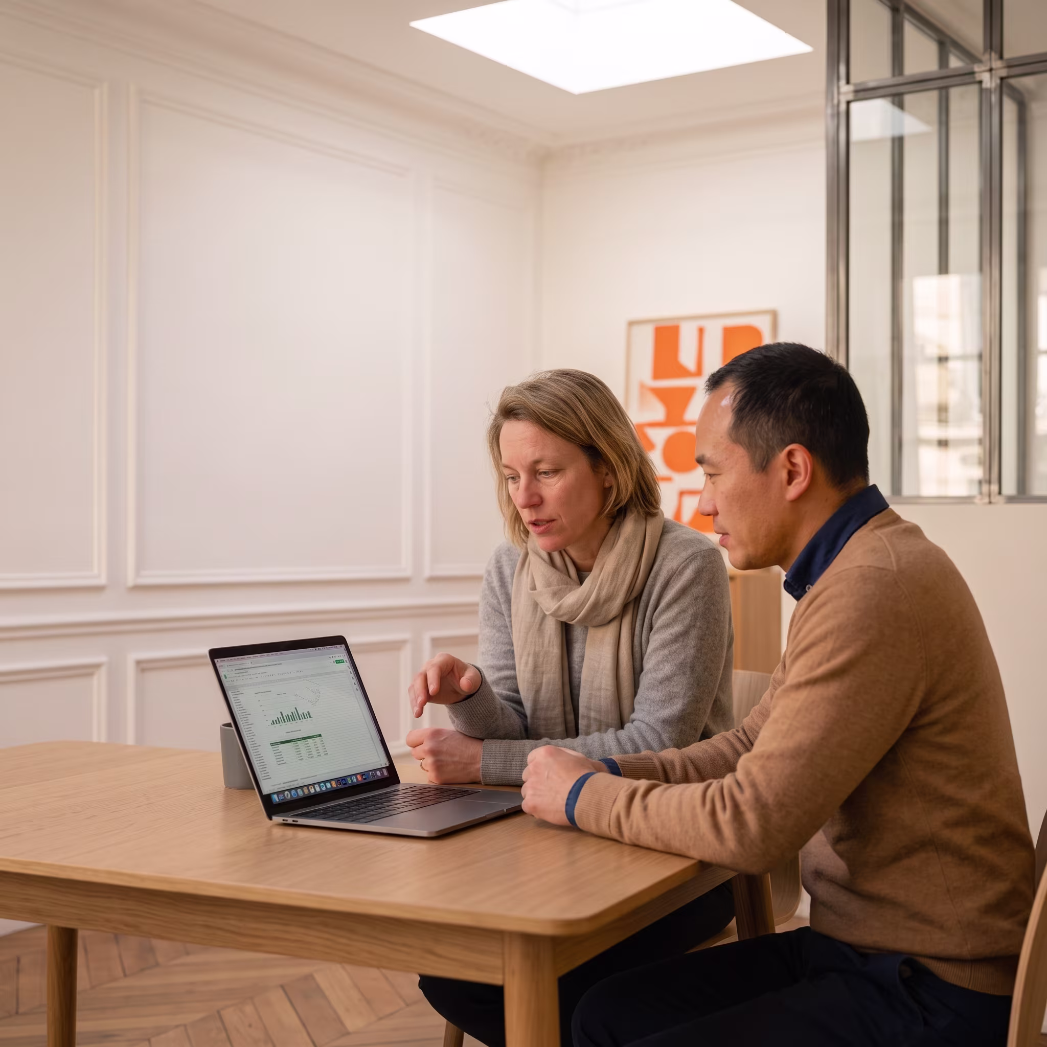 Two insurance professionals reviewing a portfolio dashboard on a laptop