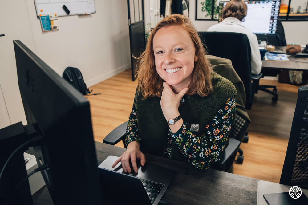 A Korint team member smiling at her desk