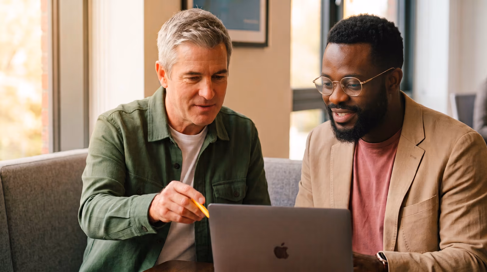 Two colleagues going through a file together on a laptop