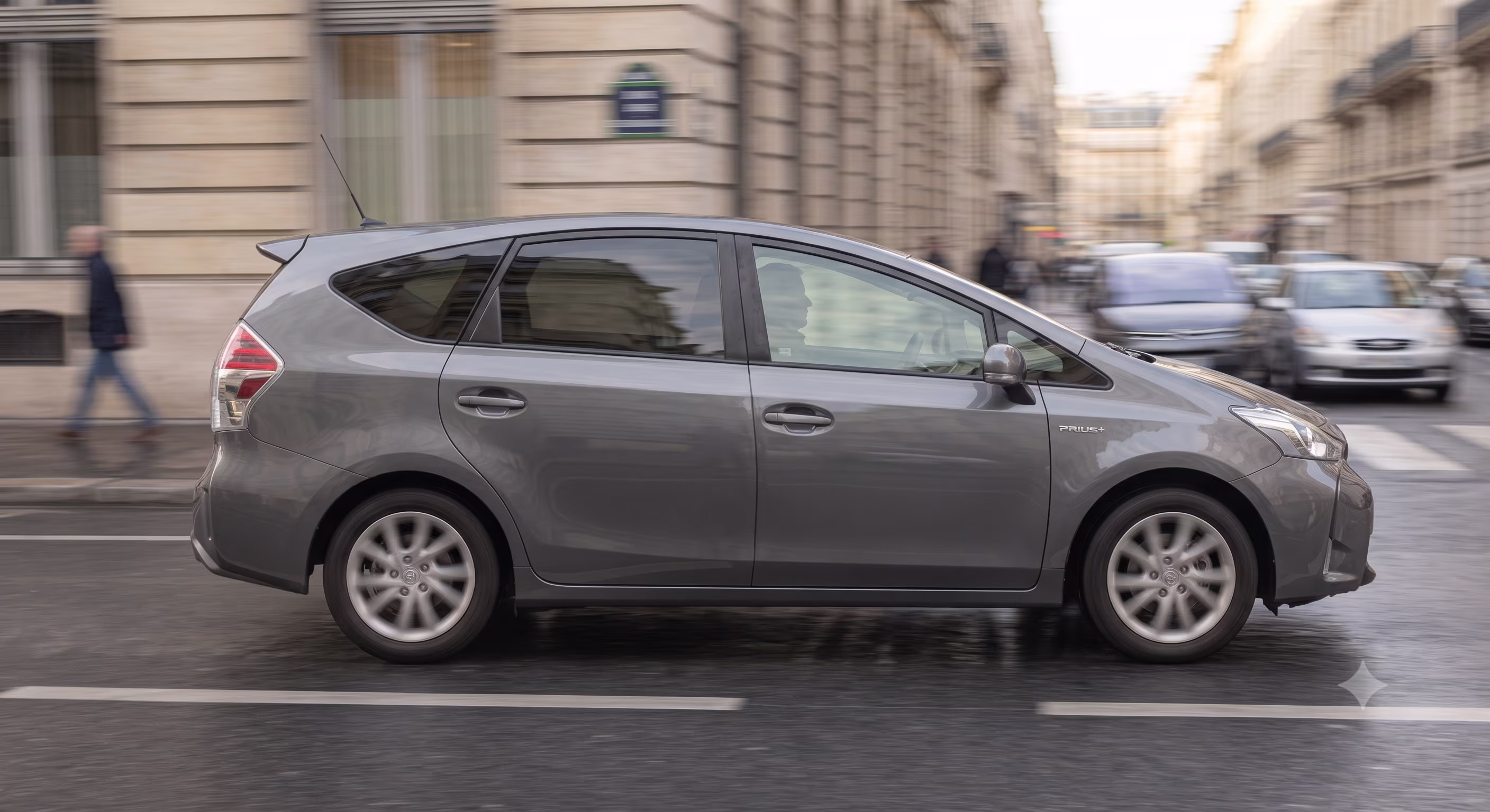 A ride-hailing car driving through a Paris street